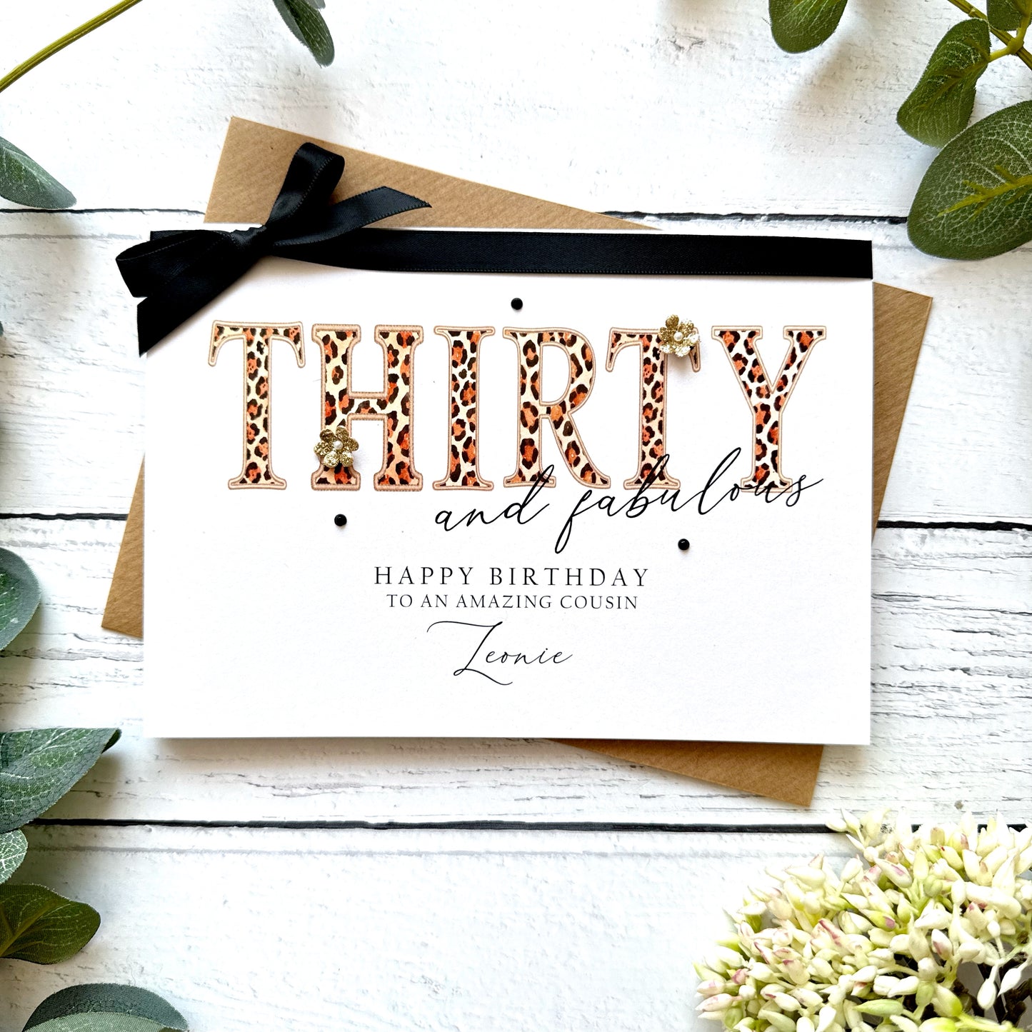 Birthday card with leopard print text 'THIRTY and fabulous' on a white background with greenery.