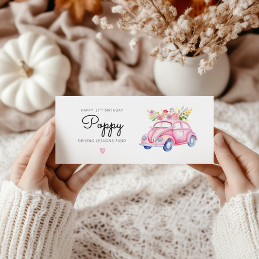 Hands holding a birthday money wallet. Text reads "Happy 17th Birthday (name) Driving Lessons Fund" Featuring a pink VW beetle car Illustration with a L plate. 