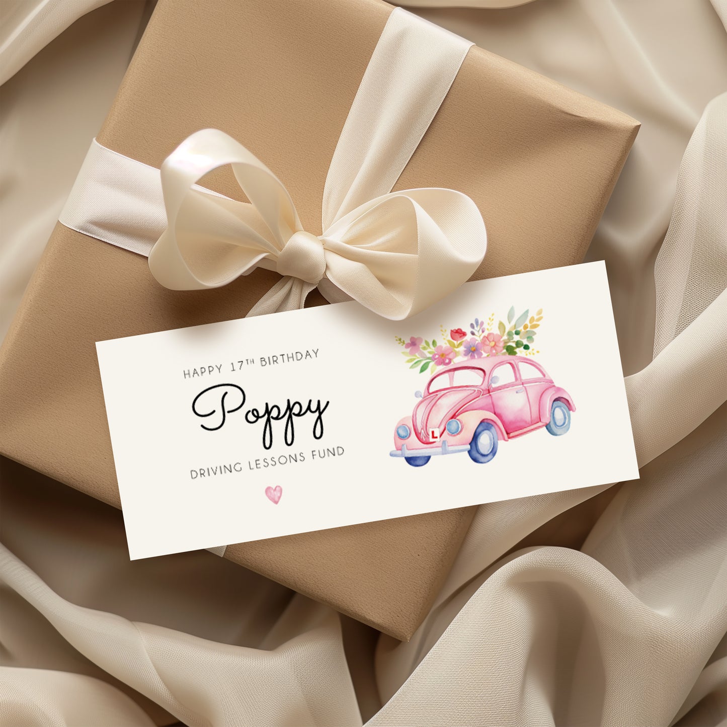 Hands holding a birthday money wallet. Text reads "Happy 17th Birthday (name) Driving Lessons Fund" Featuring a pink VW beetle car Illustration with a L plate. 