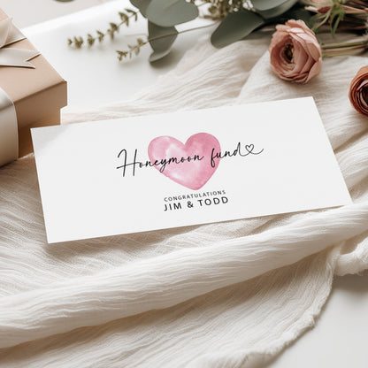 Honeymoon fund card with pink heart design on a soft fabric background