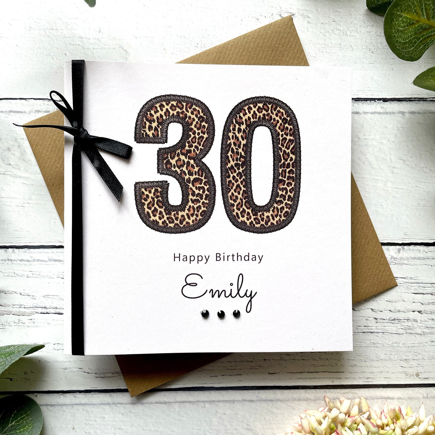 Birthday card with leopard print numbers '30' and a black bow on a white background