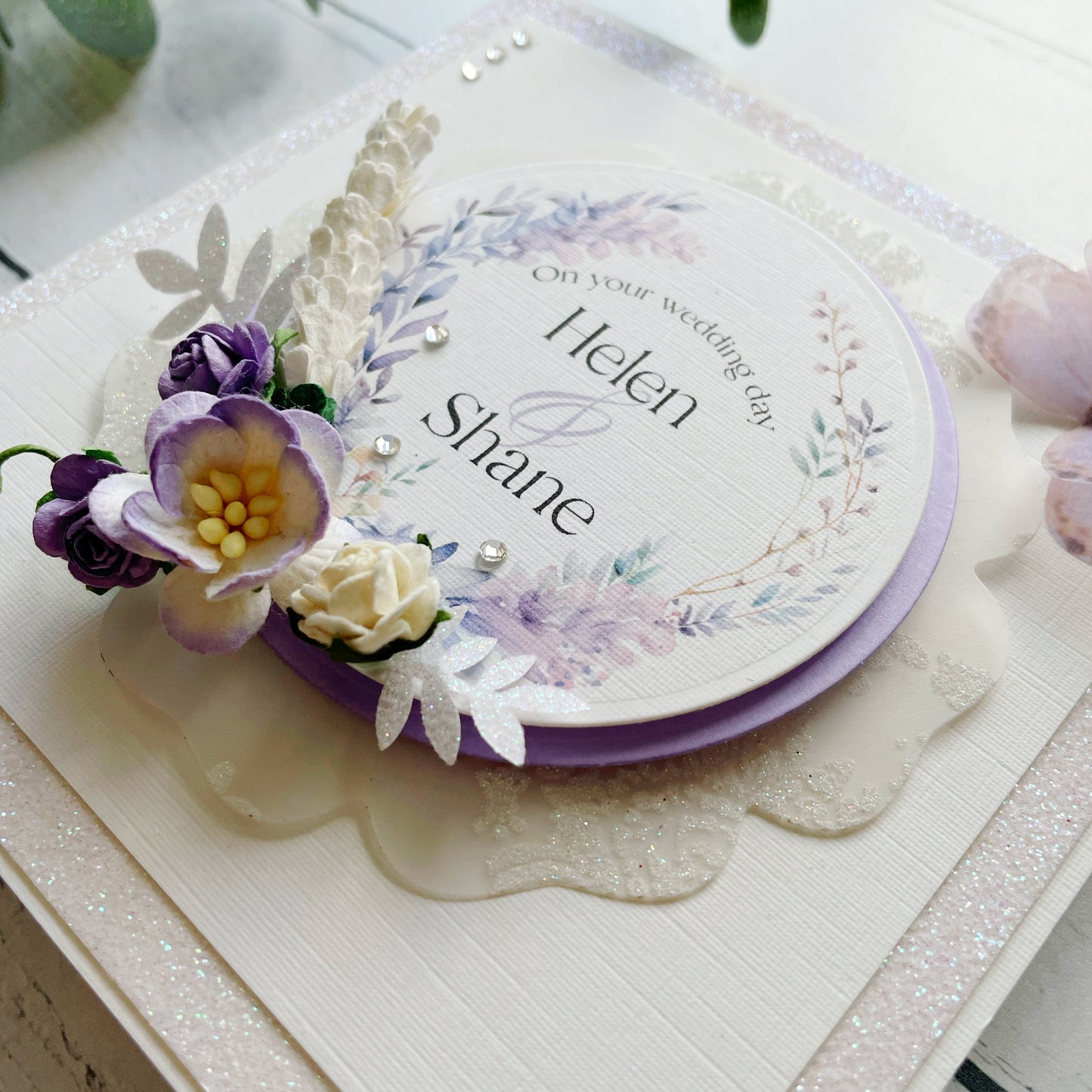 Wedding invitation card with floral decorations on a white surface