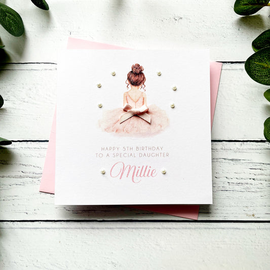 Birthday card for a special daughter with a ballerina illustration on a white wooden surface.