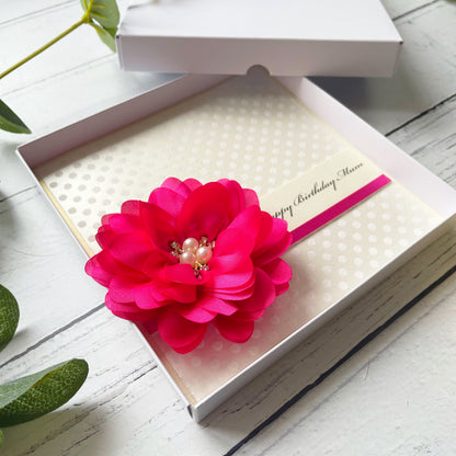 Birthday Card with Fuchsia Pink flower embellishment with pearl center on a polka dot flocked paper. in a white box.