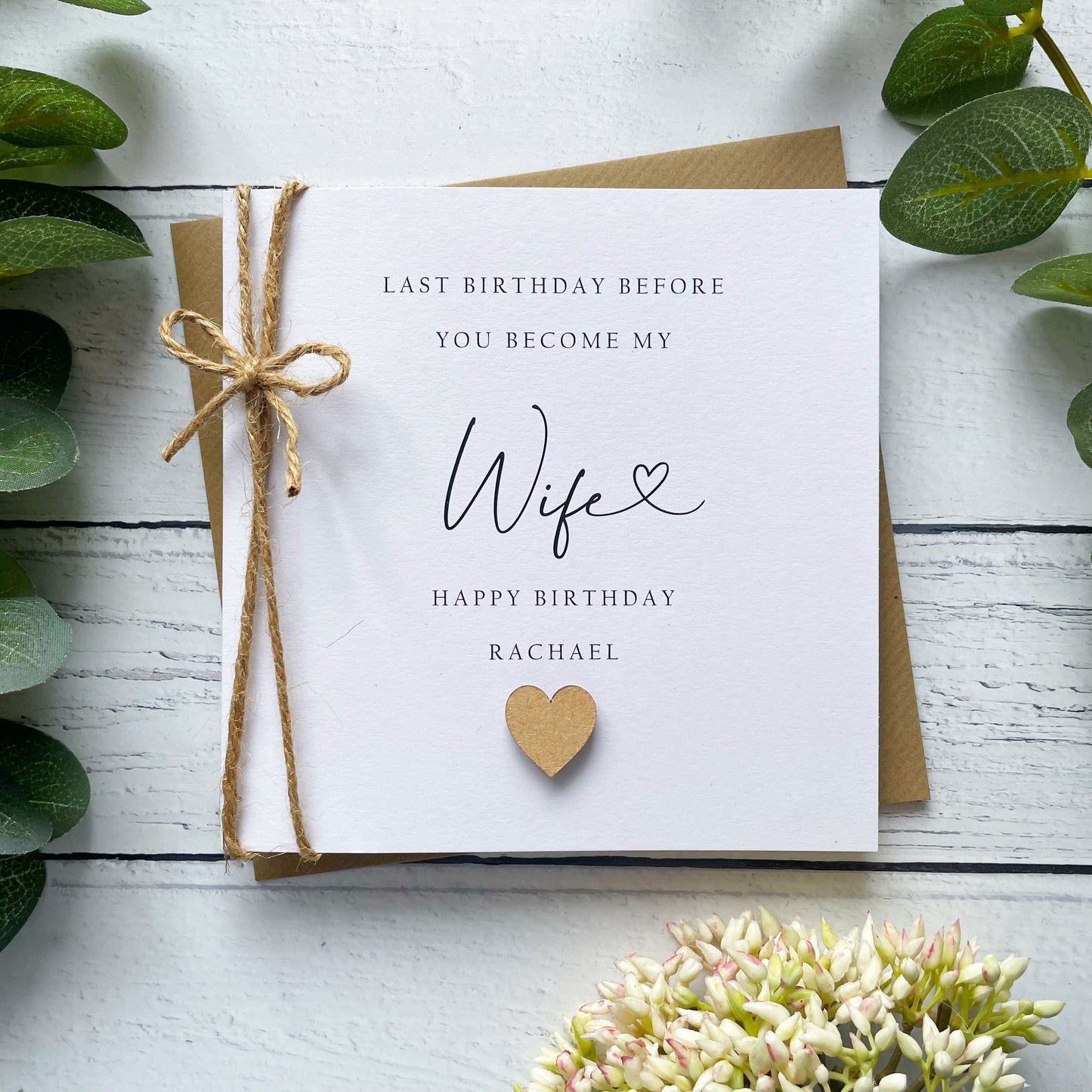 Personalised birthday card for a future wife on a white wooden surface with greenery.