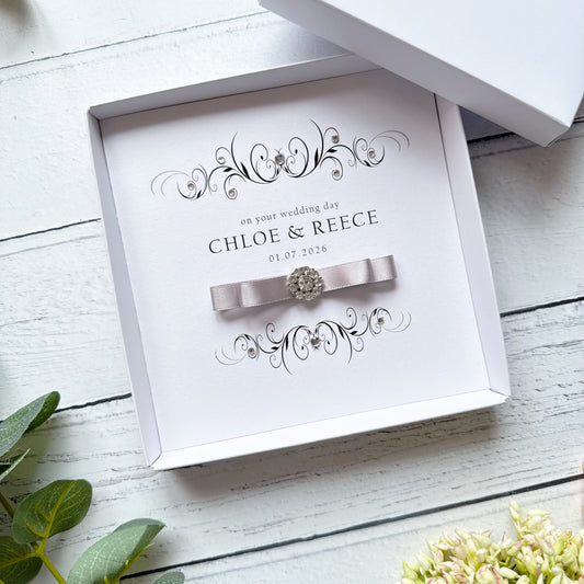 Personalised wedding card in a box. With a pleated bow and crystal embellishment. With text on your wedding day, followed by names and wedding date.