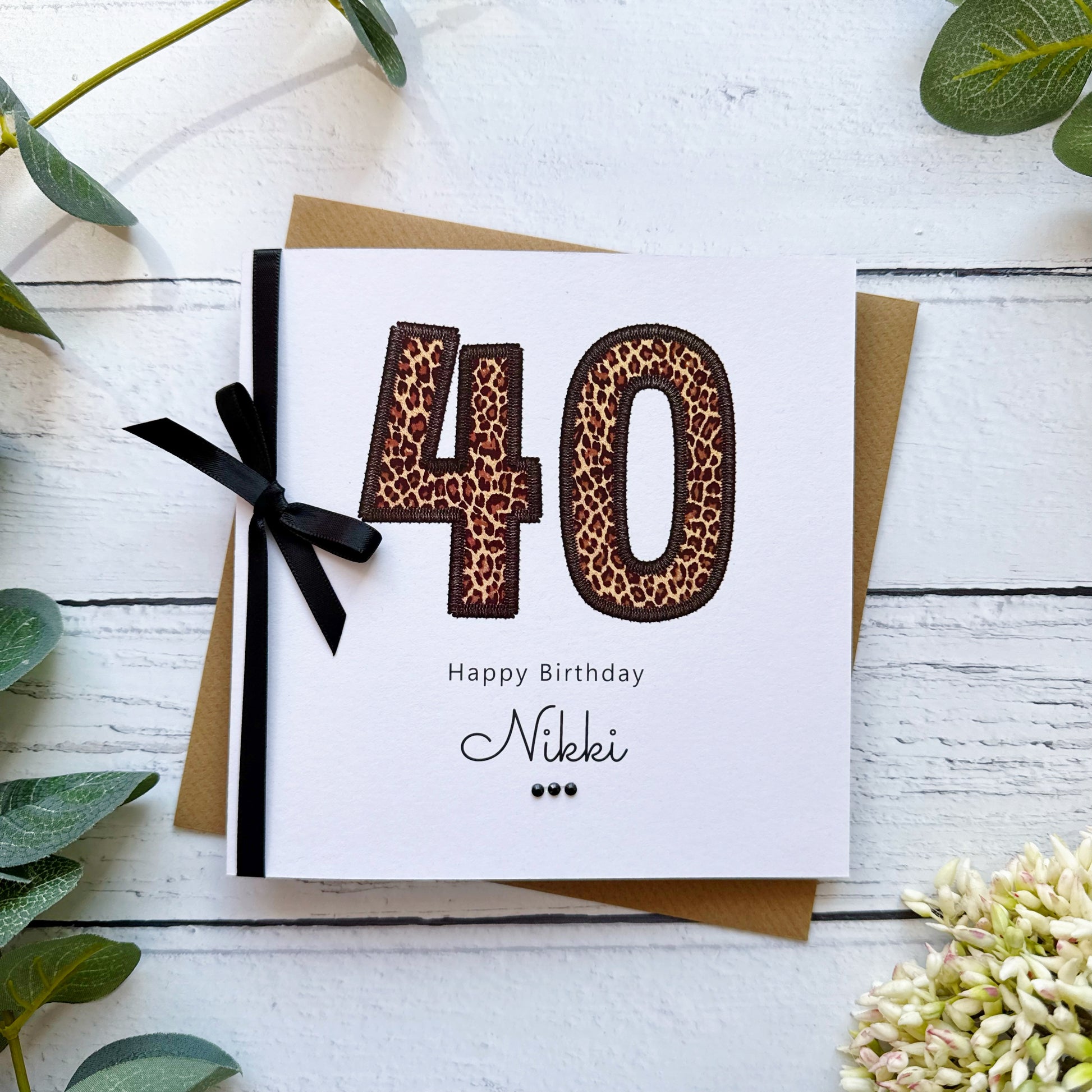 Birthday card with leopard print numbers '40' and a black bow on a white background.