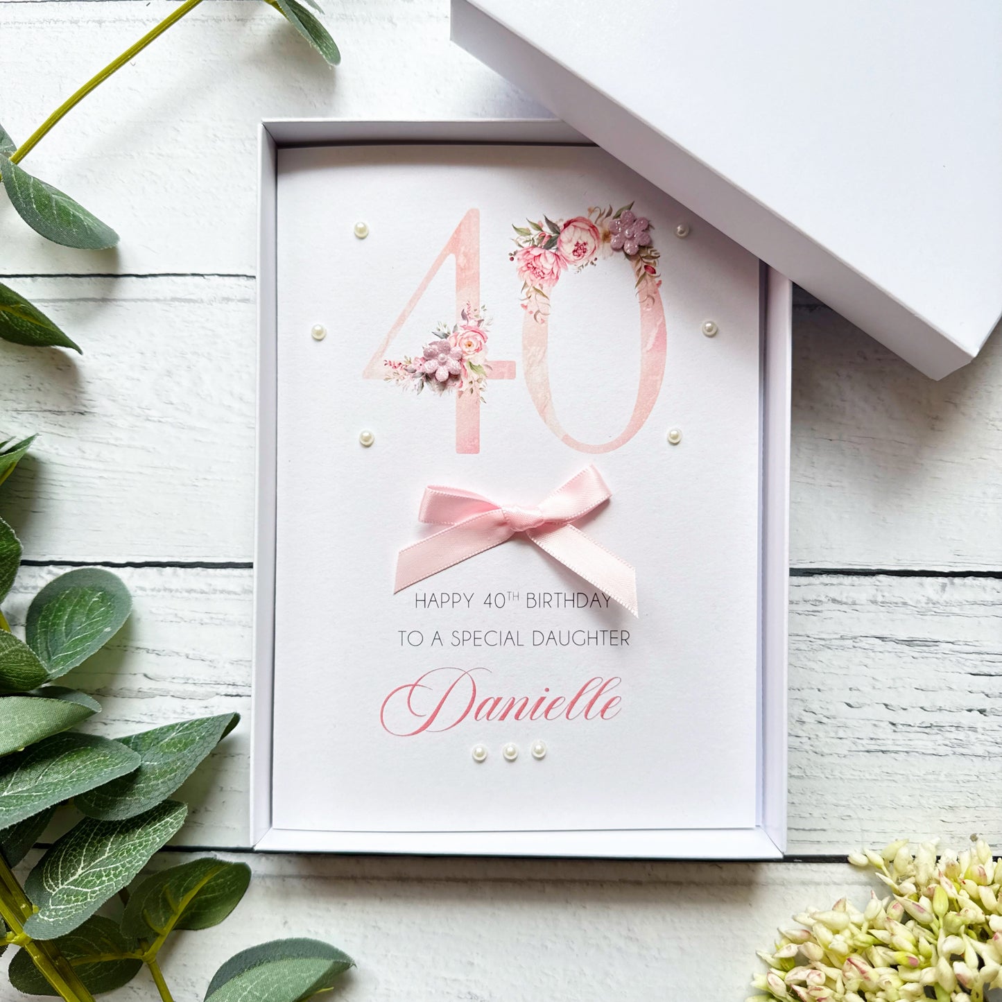 Personalised 40th birthday greeting card with floral design and pink bow on a white background