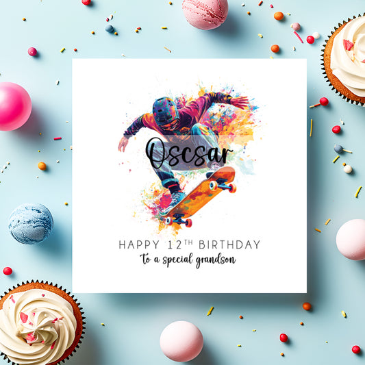 A square white birthday card featuring a vibrant watercolour illustration of a skateboarder mid-trick, wearing a helmet, orange and purple jacket and dark trousers, riding an orange skateboard, surrounded by colourful paint splashes in yellow, pink, blue and orange. The name "Oscar" is overlaid in bold cursive script across the centre of the illustration. Below, the text reads "Happy 12th Birthday" in spaced capitals, followed by "to a special grandson" in flowing script. 