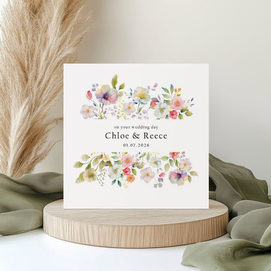 Floral wedding card with personalised text details on a wooden stand with decorative elements